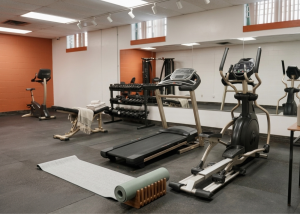 Modern on-site student fitness room at 1029 Main with premium cardio machines, treadmills, and free weights workout area for female residents.