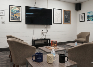 Bright and comfortable student housing shared lounge featuring a large TV screen, couches and a chess table.