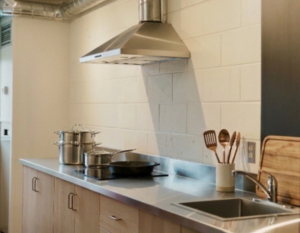 Clean shared kitchenette in a secure all-female student housing building with modern counters.
